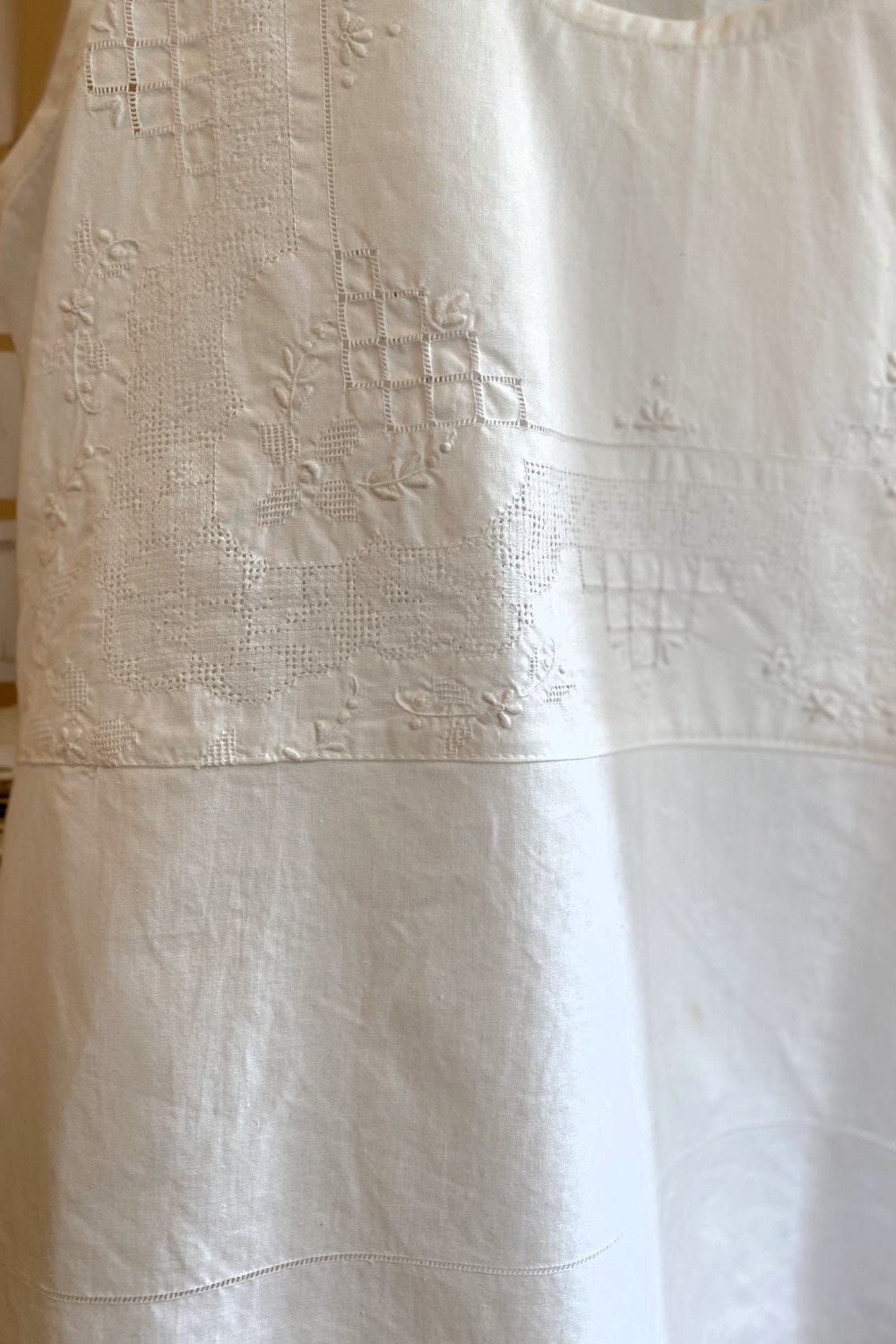 Close up of stitching detail on white vintage tablecloth tank.