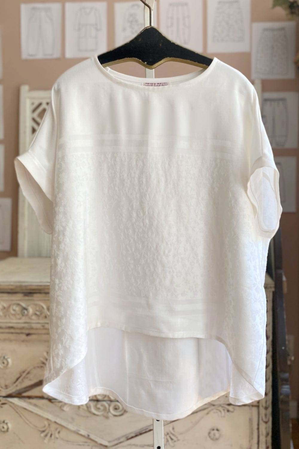 Short sleeve women's white curved hem top with damask linen detail.