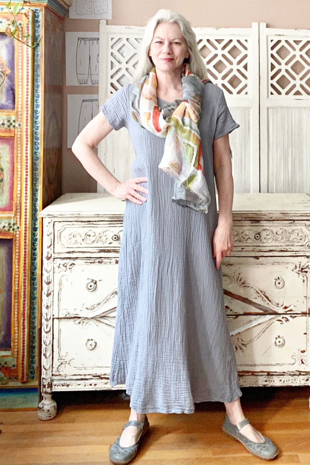 Light Grey Textured cotton long dress with multi colored scarf worn on older  stylish woman.