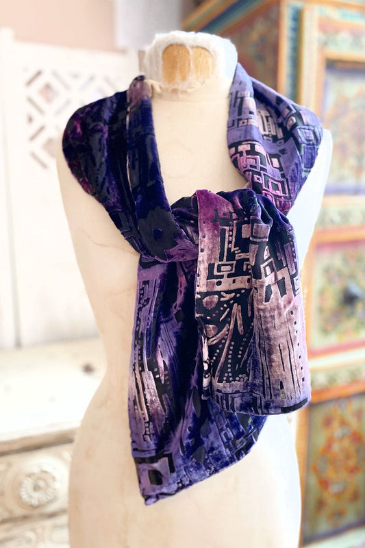 Cutout purple velvet scarf draped over a vintage dress form.