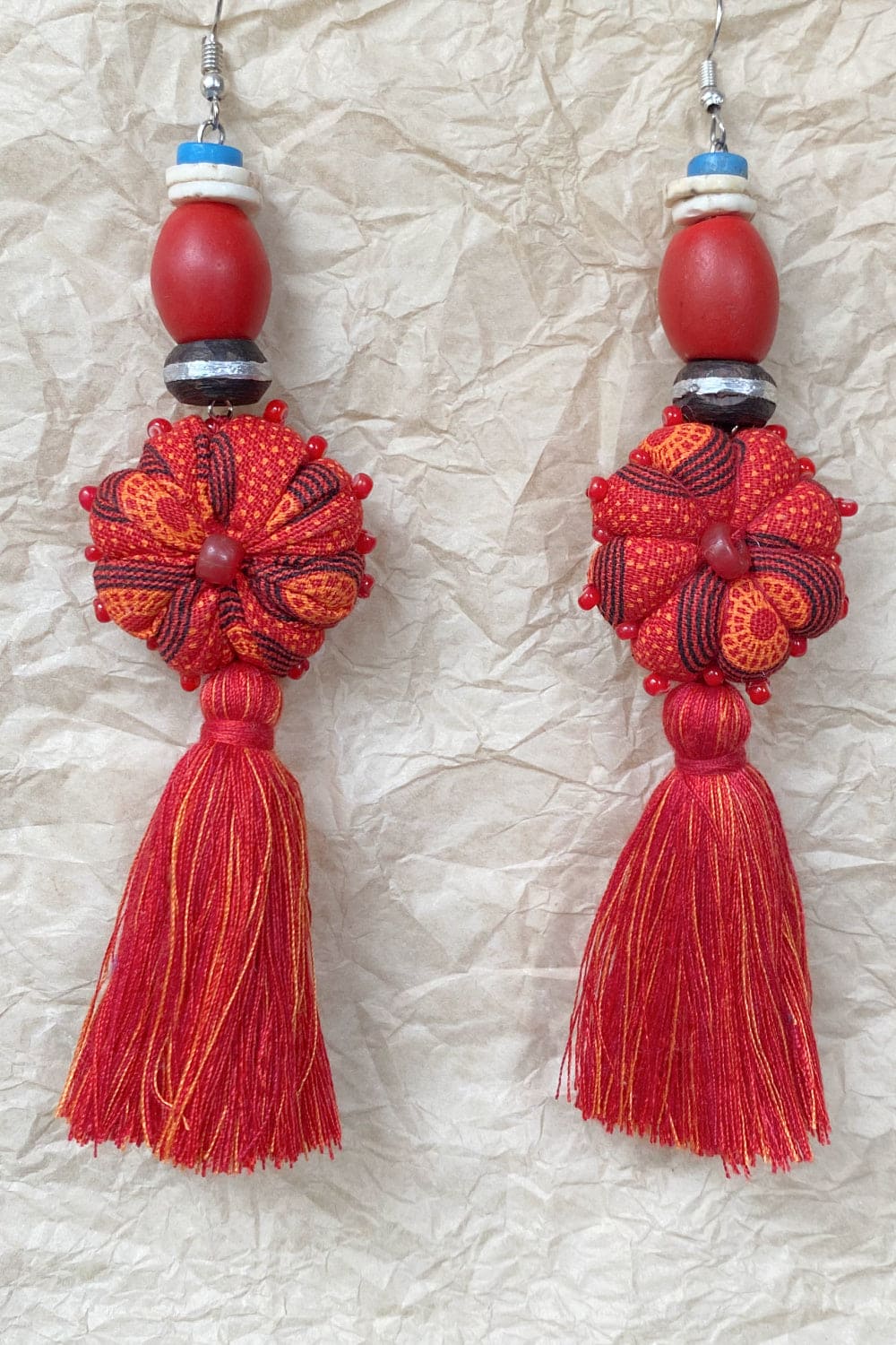 Handcrafted tassel earrings with red bead.