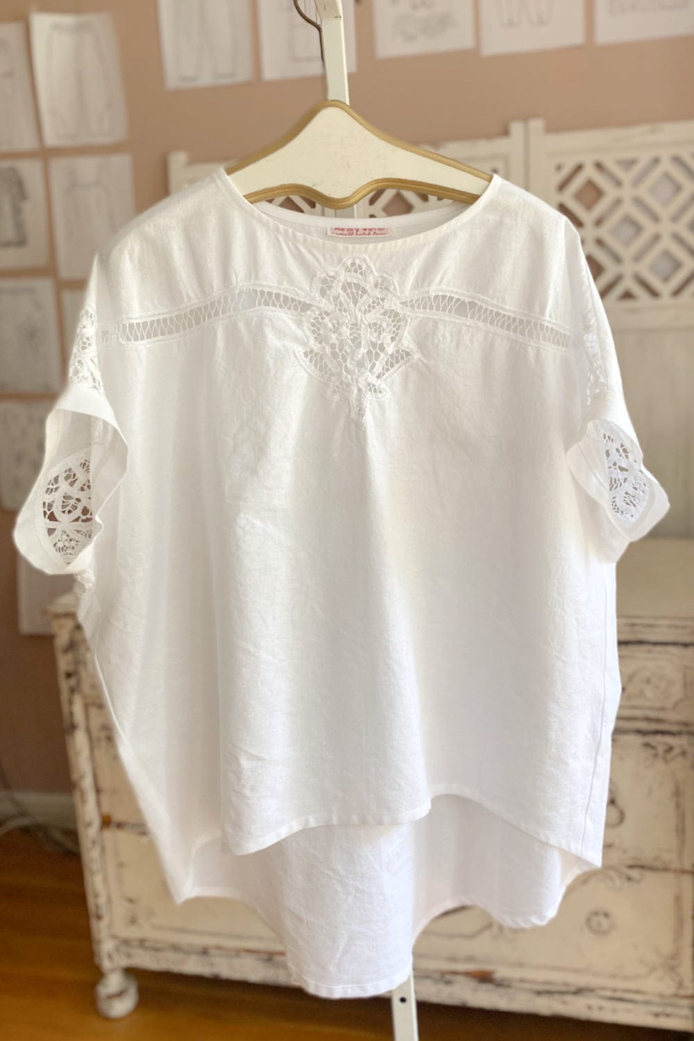Short sleeve women's cotton top with decorative stitchig and a curved hemline.