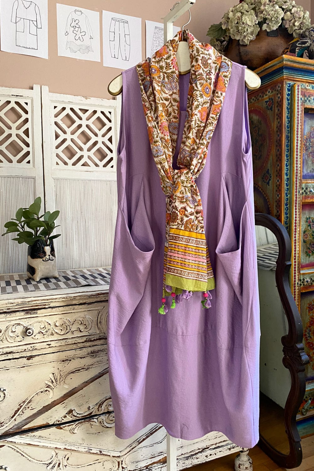 Lavender tank dress with two front pockets. A pretty floral scarf is draped infront.