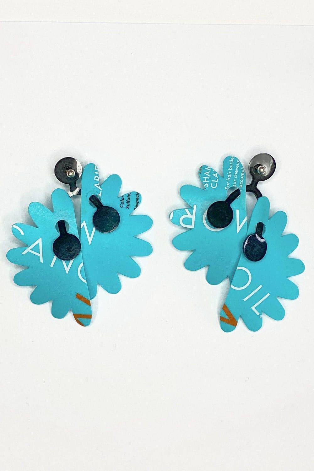 Recycled Plastic Earrings cut in a floral shape. Aqua color with random print and black detail.