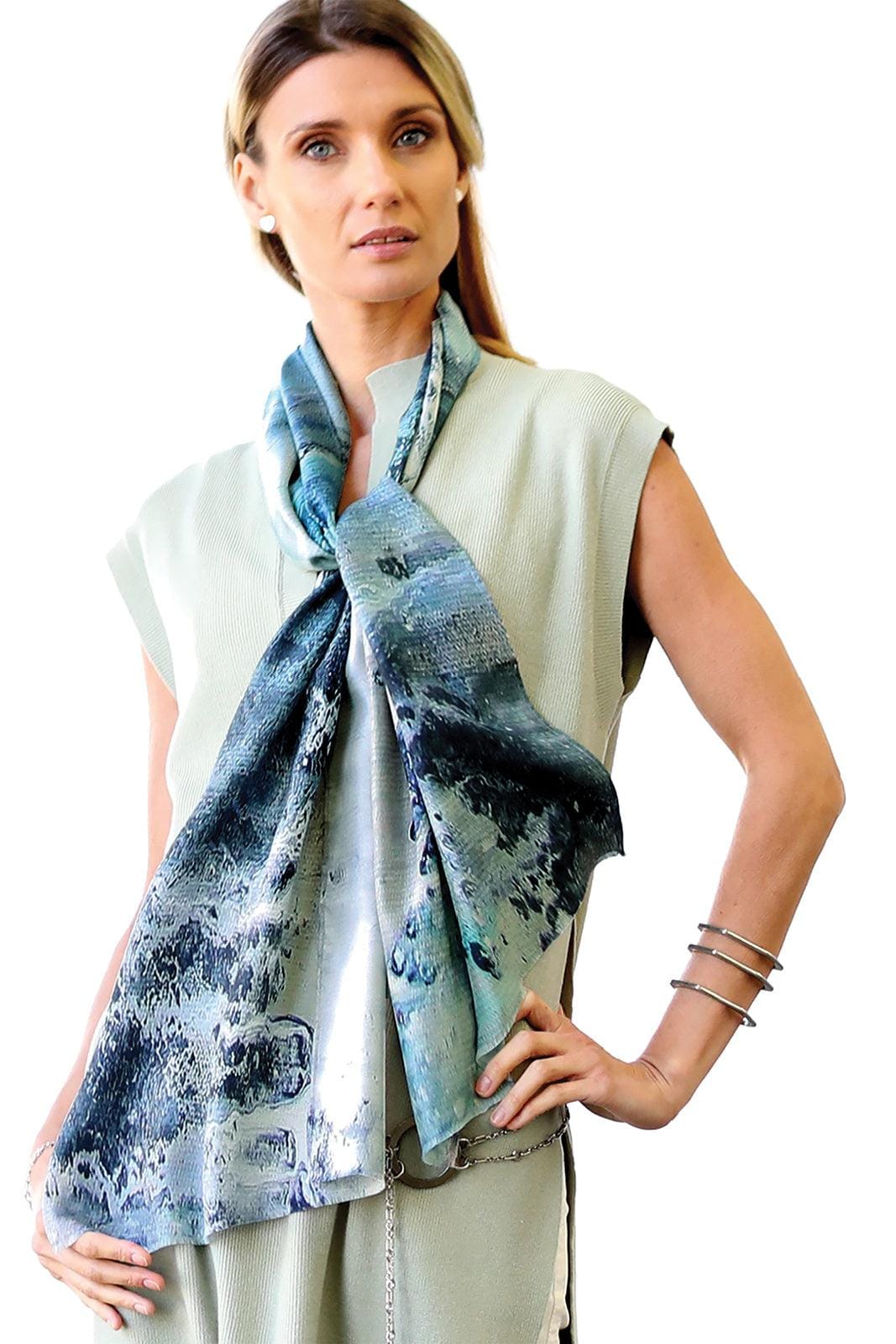 Crushed Pebble Silk Scarf in blues being worn over a soft green jumpsuite. It is worn long and is a rectangle shape.