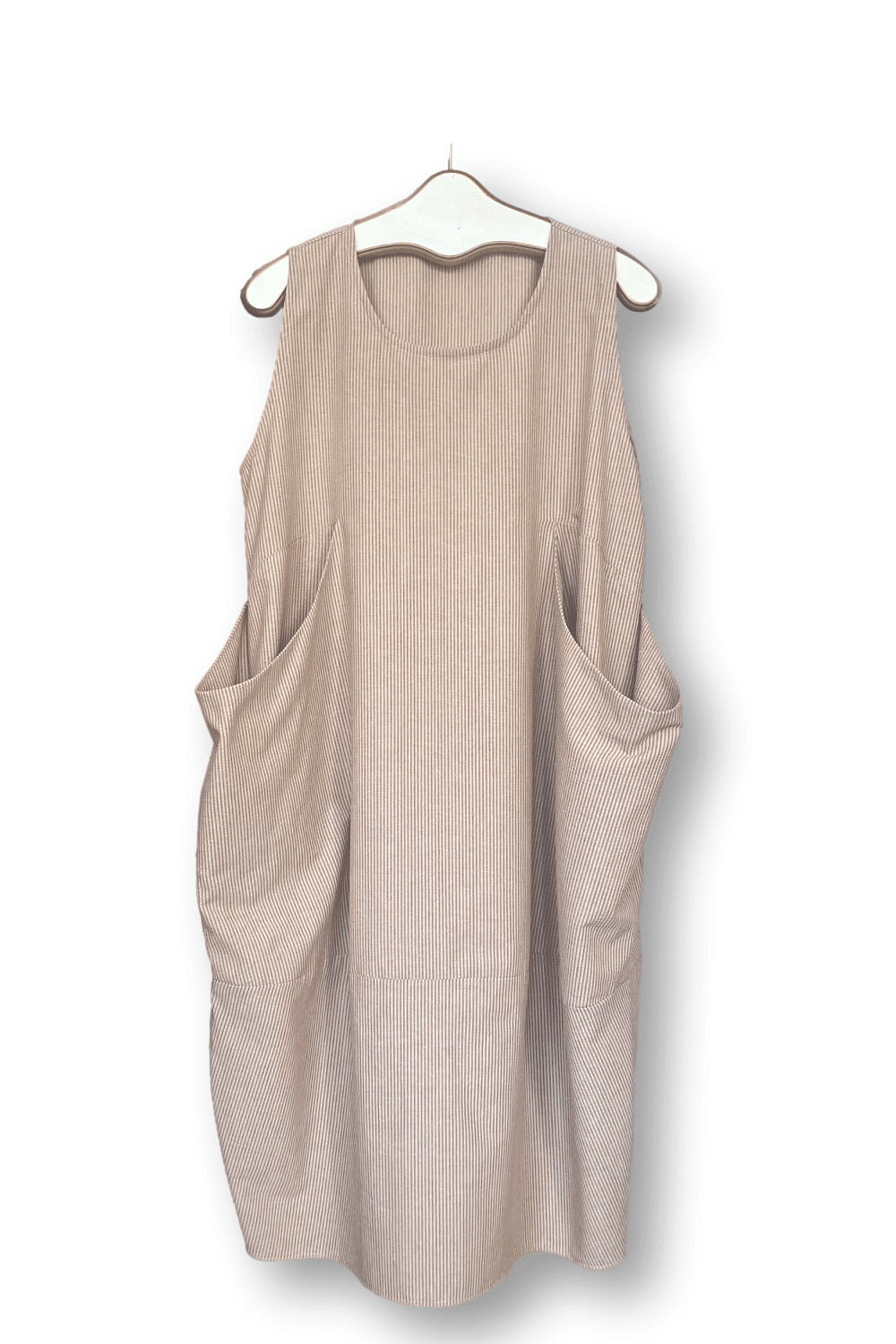 Tank dress with a slight bubble shape. It has 2 large front pockets and is a mocha colored seersucker fabric.