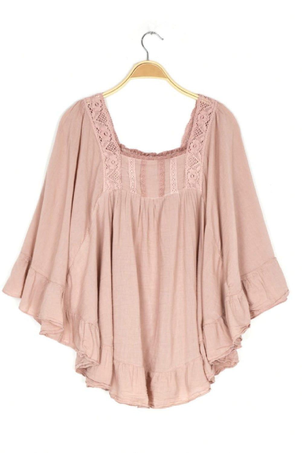 Soft ballet ping cotton blouse with detail and curved ruffle hemline handing on a hanger.