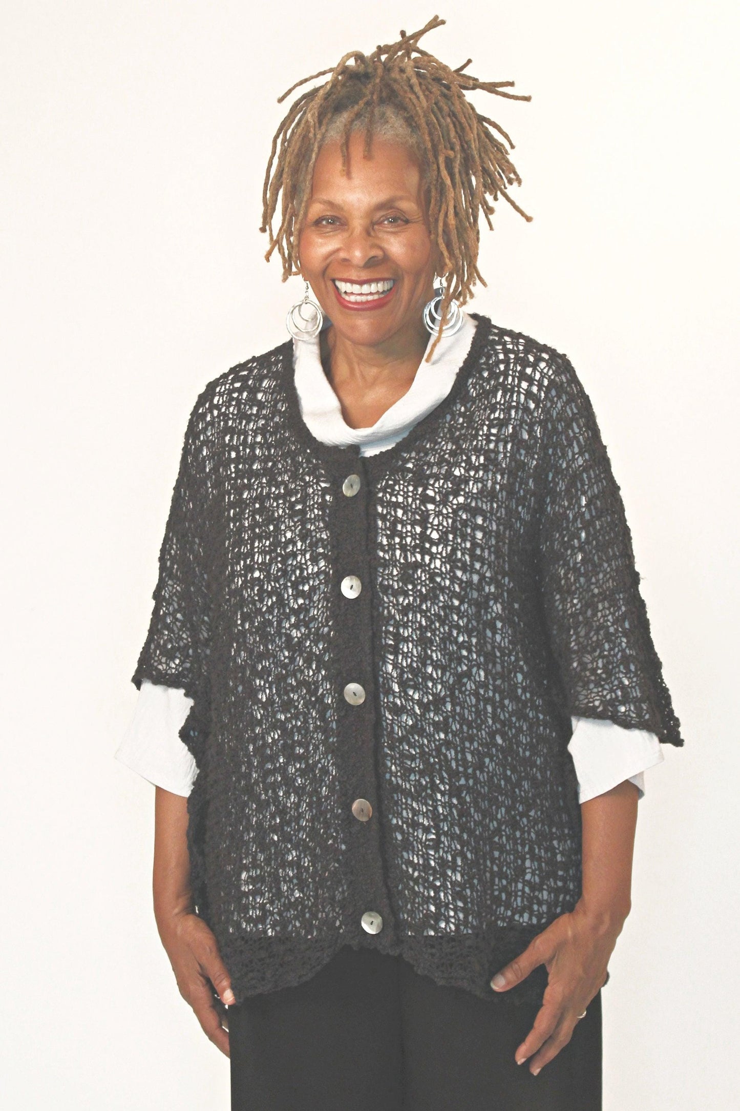 Smiling woman wearing a loose knit Black Button Cardigan sweater.