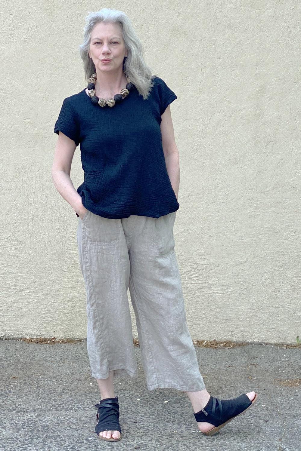 Black cotton tee aline shape with short sleeves worn with loose fit linen pants.