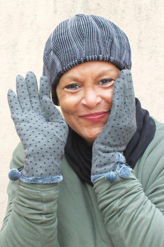 Hand Knit Cotton Tam and polka dot gloves with pom poms worn on a smiling woman.