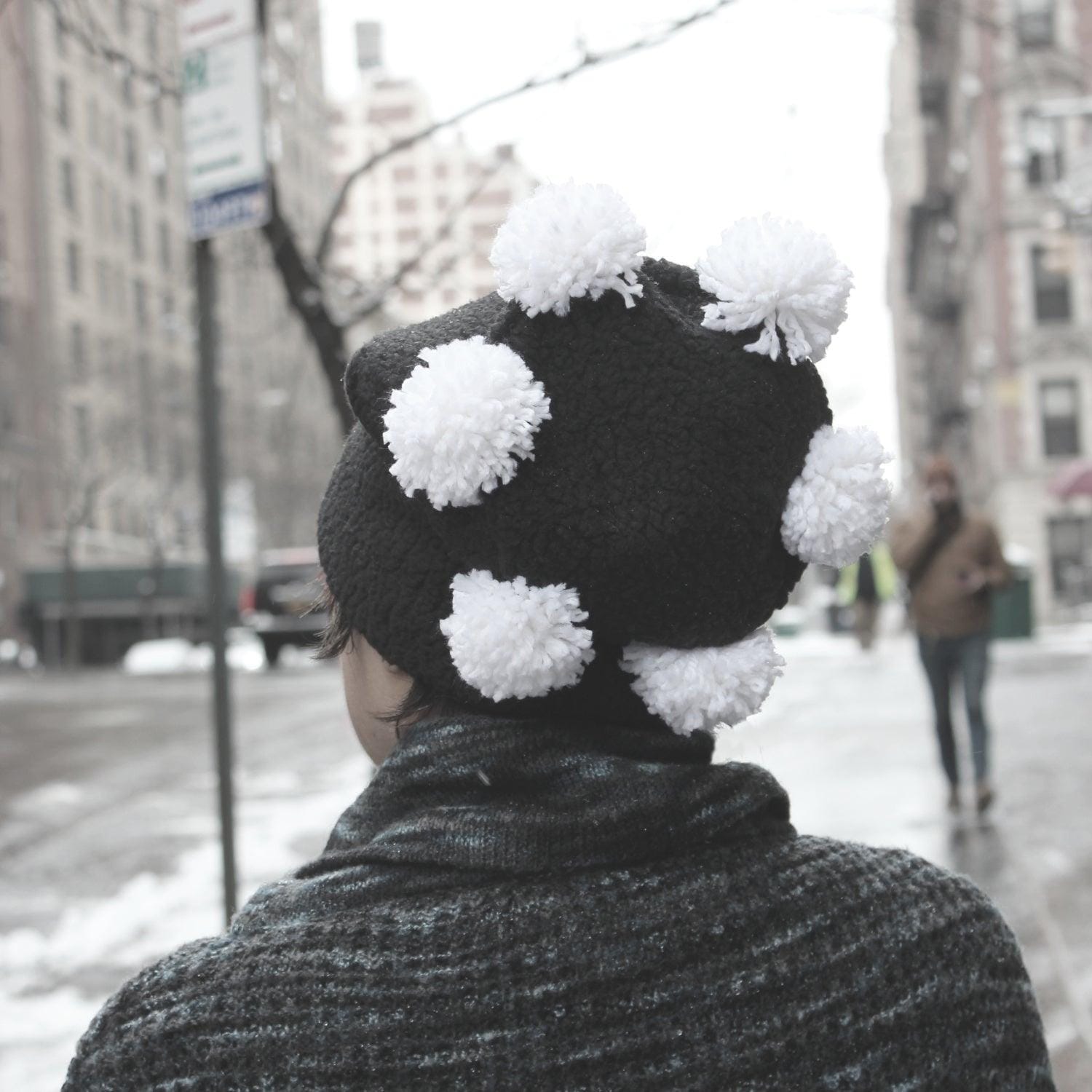 Back view of Soft Women's Hat Black with white pom poms crowning the top.