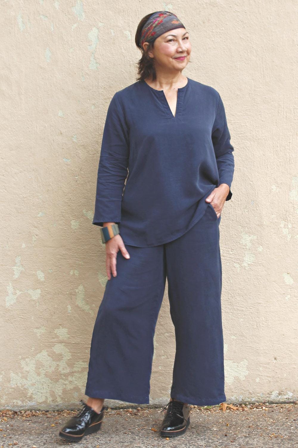 Crop Tencel Full Cut Pant with 2 side pockets being worn with a matching split neck long sleeve top. The model is smiling and wearing a hair band and black front tie shoes.