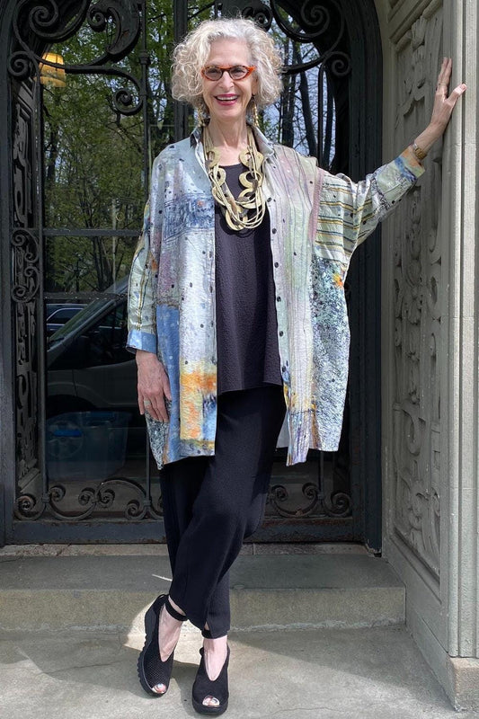 Older woman wearing a Bottom Detail Pant with an oversized buttondown shirt and taupe statement necklace.