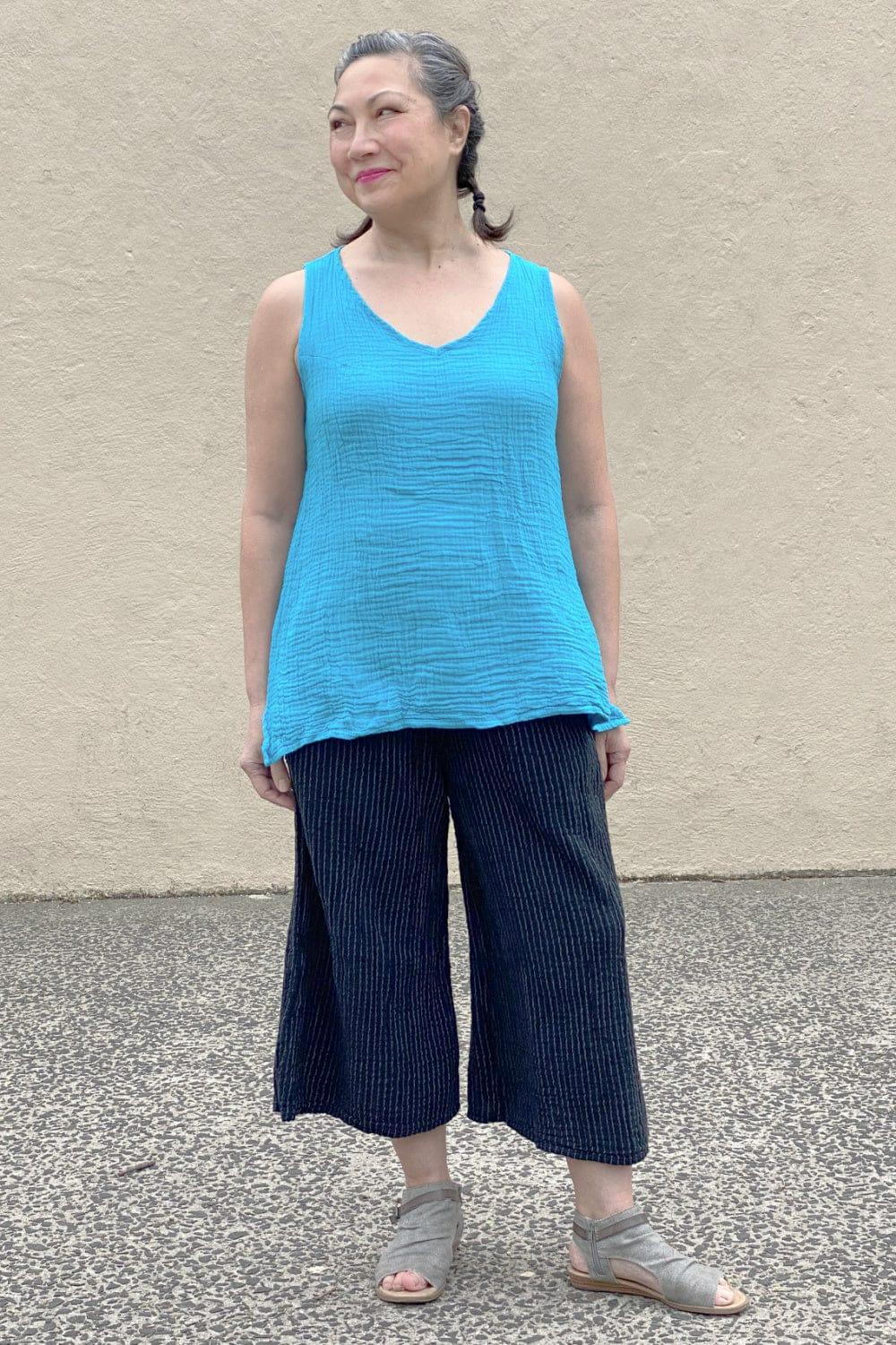Woman wearing a Turquiose Cotton Crinkle Tank with black full cut pants.