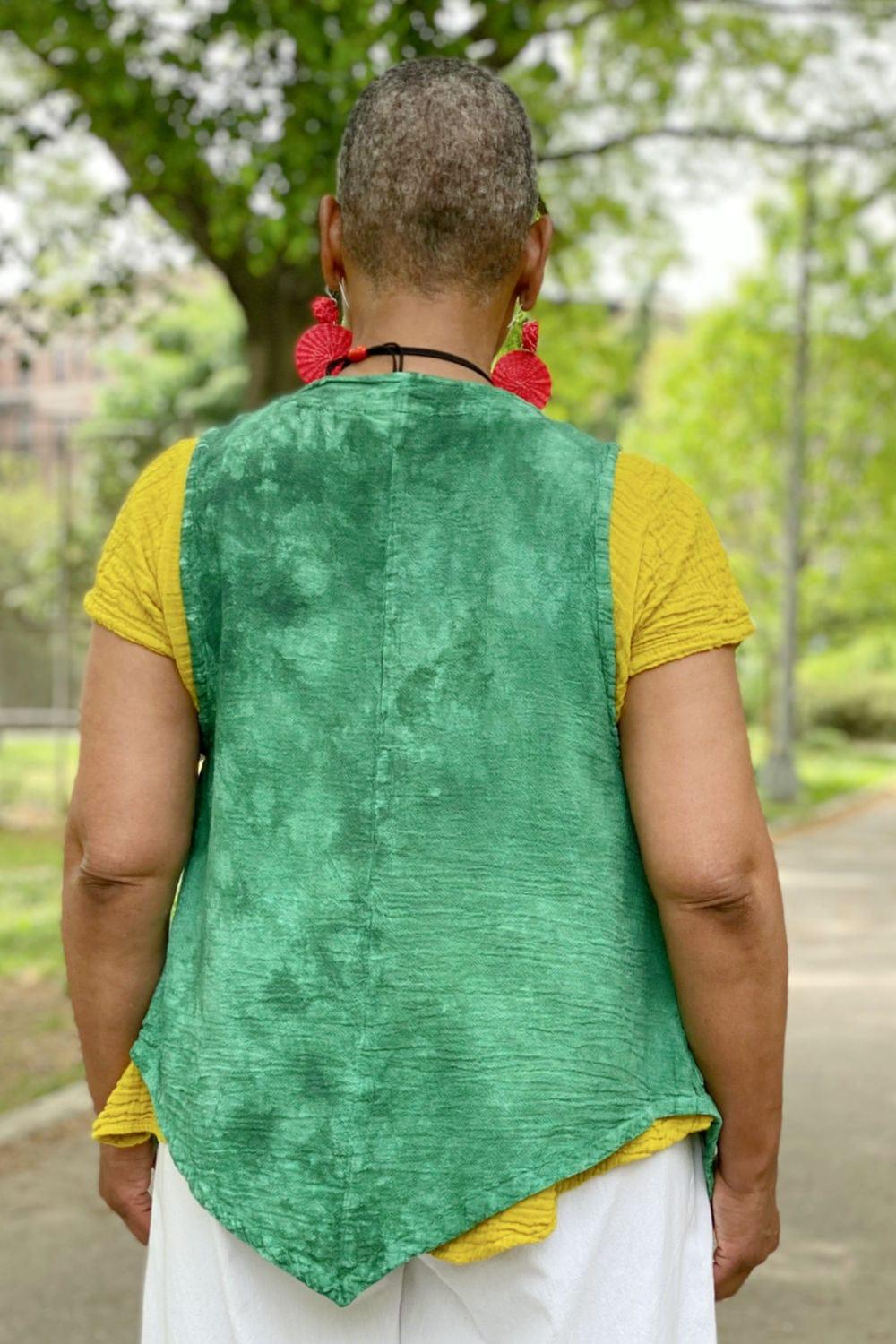 Back view of a woman wearing a cotton jade green vest with a short sleeve cotton tee.
