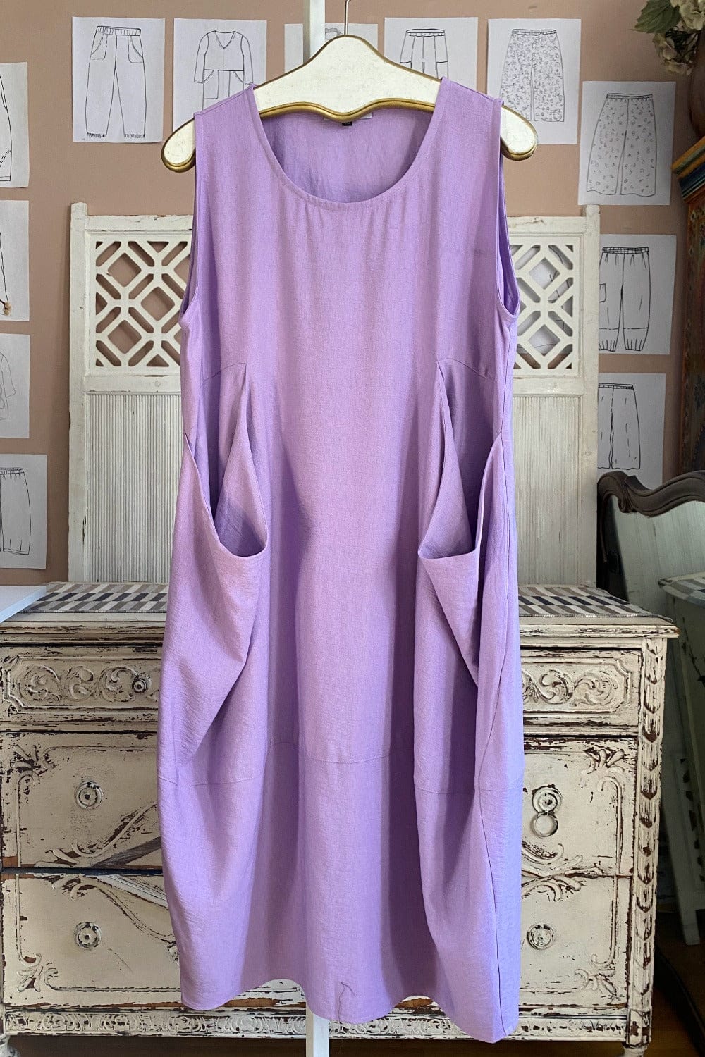 Pretty lavender two pocket tank dress hanging on a vintage hanger.