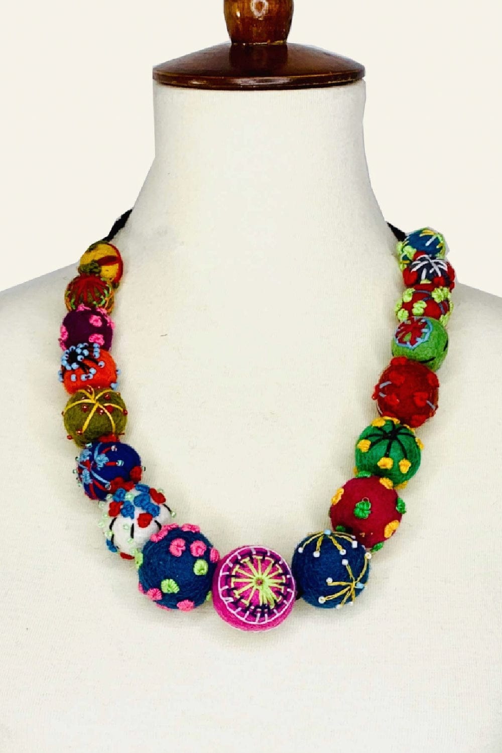 Multi colored felted Necklace made of hand stitched felted balls with stitching detail.