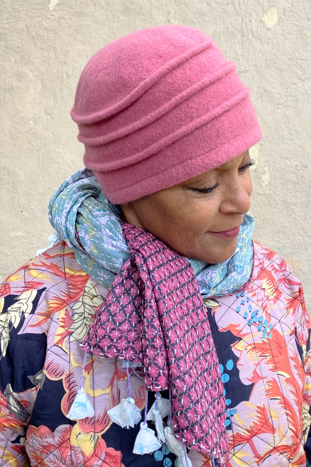 Wool Cloche Hat with Pleats in a soft pink being worn with a pink and blue cotton kantha stitch scarf.