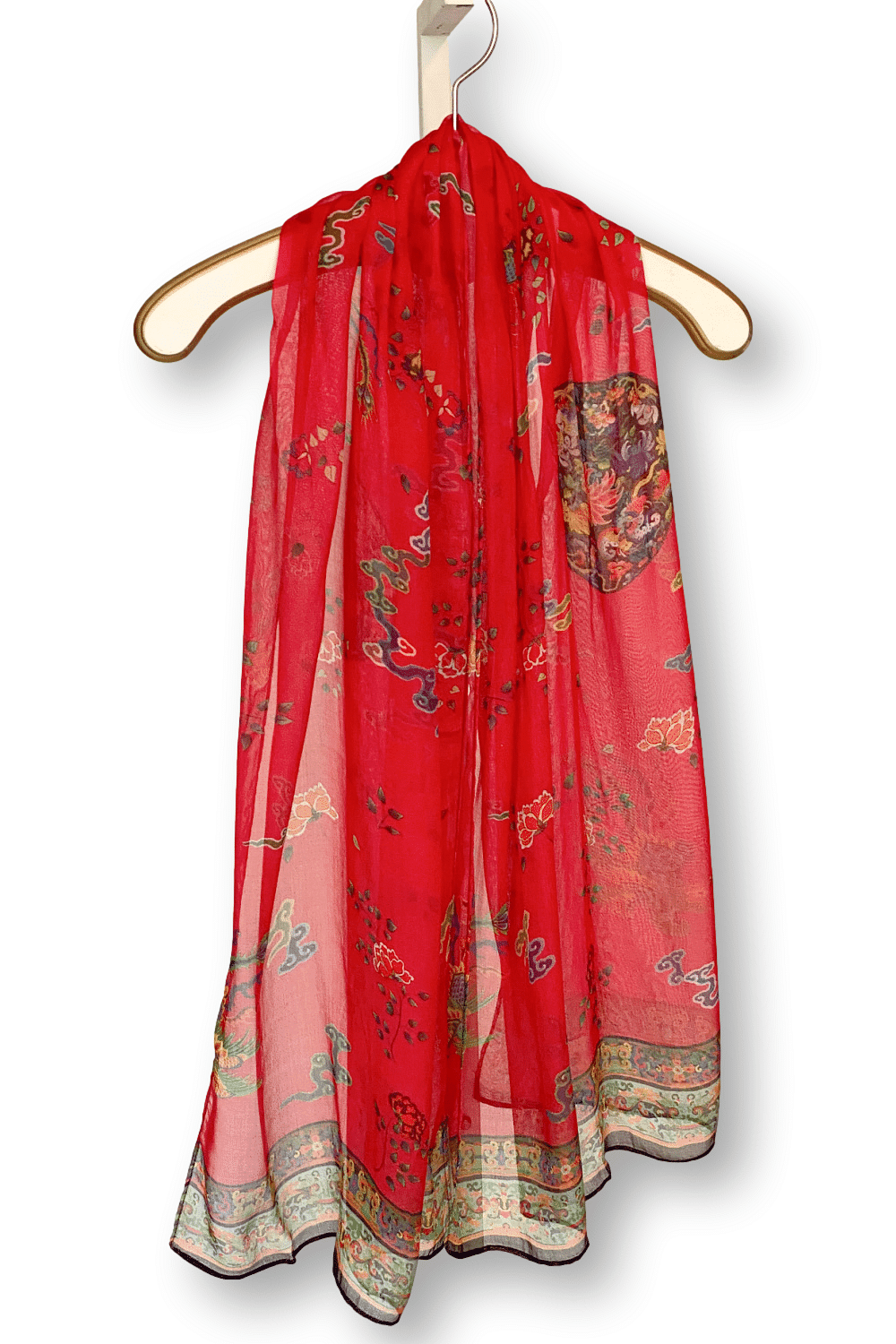 Lightweigh sheer red scarf with an asian influence print and boarder design. It is draped over an antique creme hanger with gold trim.