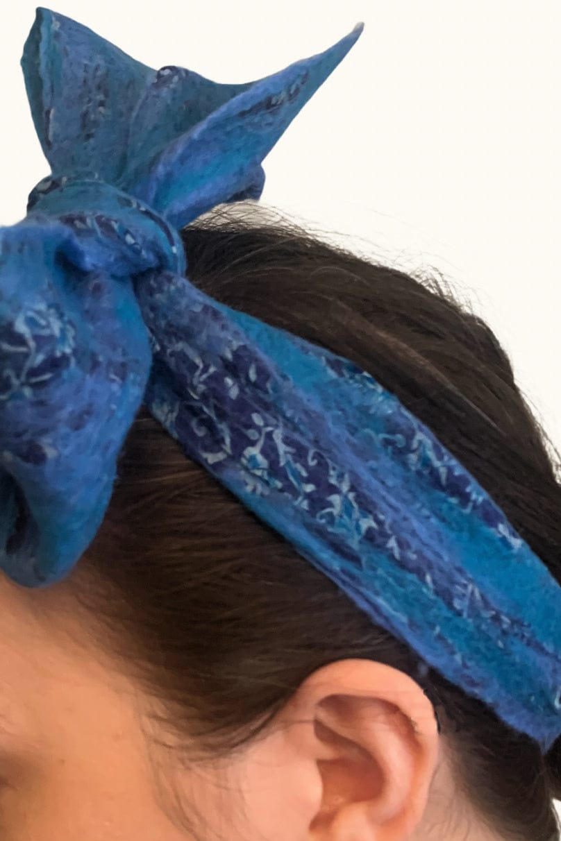Close up of a blue sari head scarf bowed in a women's hair.