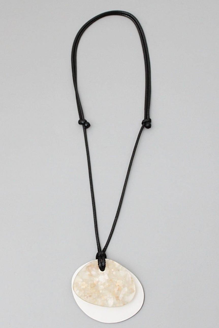 Simple pendant necklace with two layers of resin flat beads, one solid cream and one with flecks strun on an adjustable black cord.
