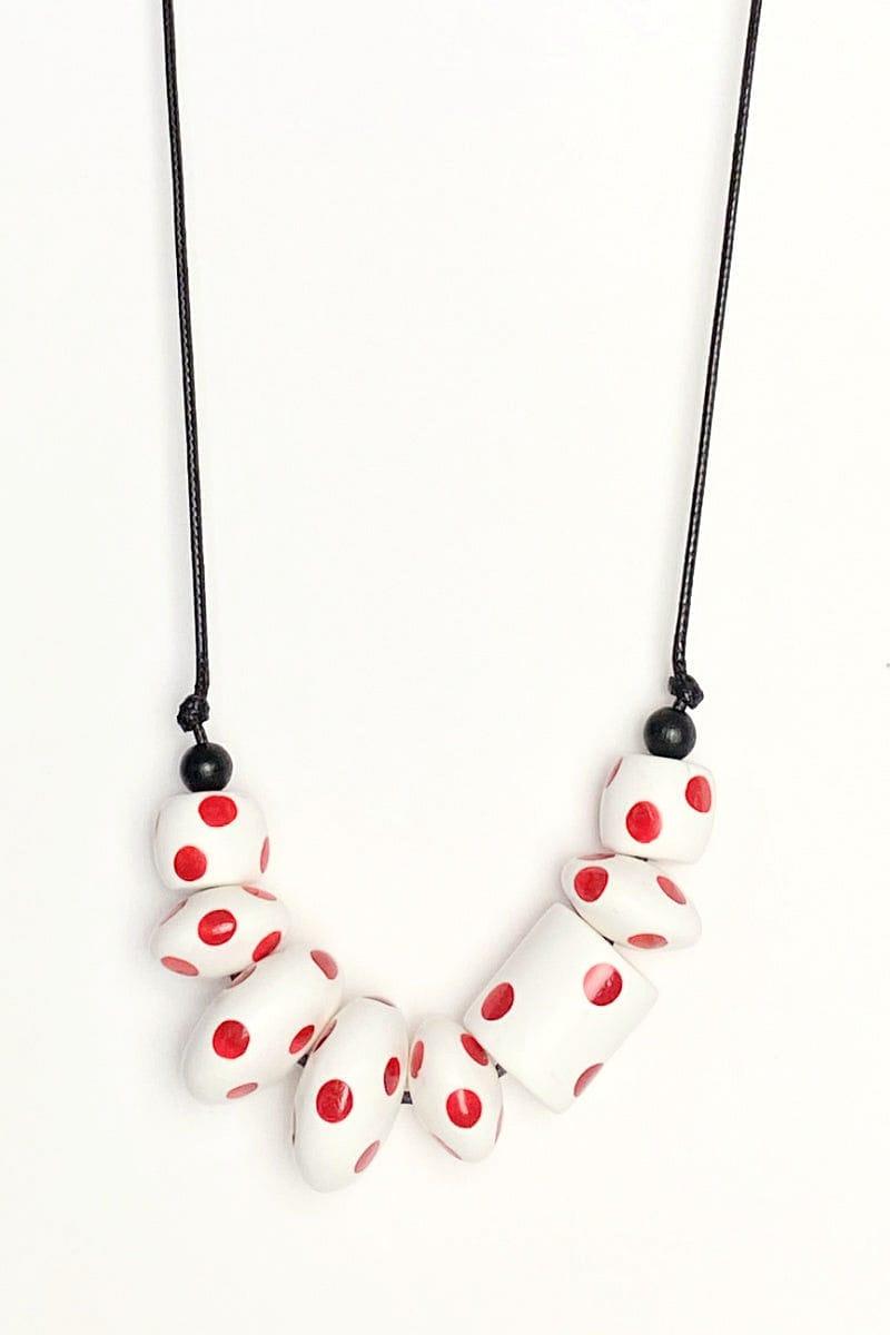 White wooden bead with red polka dots necklace and matching earrings. Necklace strung on a wax black adjustable cord. Beads are shaped in assorted round shapes. 