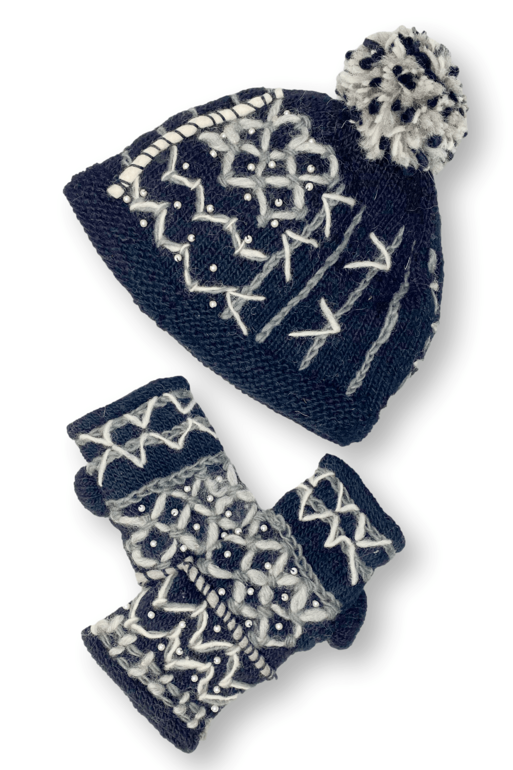 Woman's wool beanie with fleece lining decorated with with stiching and a black and white pom pom. Show with matching fingerless gloves.