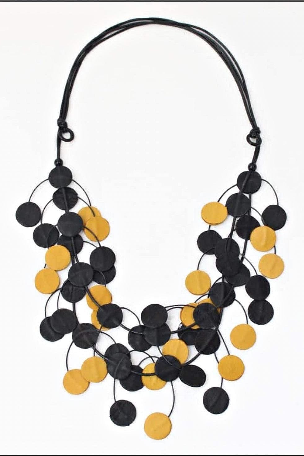 Multi Yellow and Black Leather Dots Necklace designed with small flat leather discs intertwining and strung on an adjustable black cord.