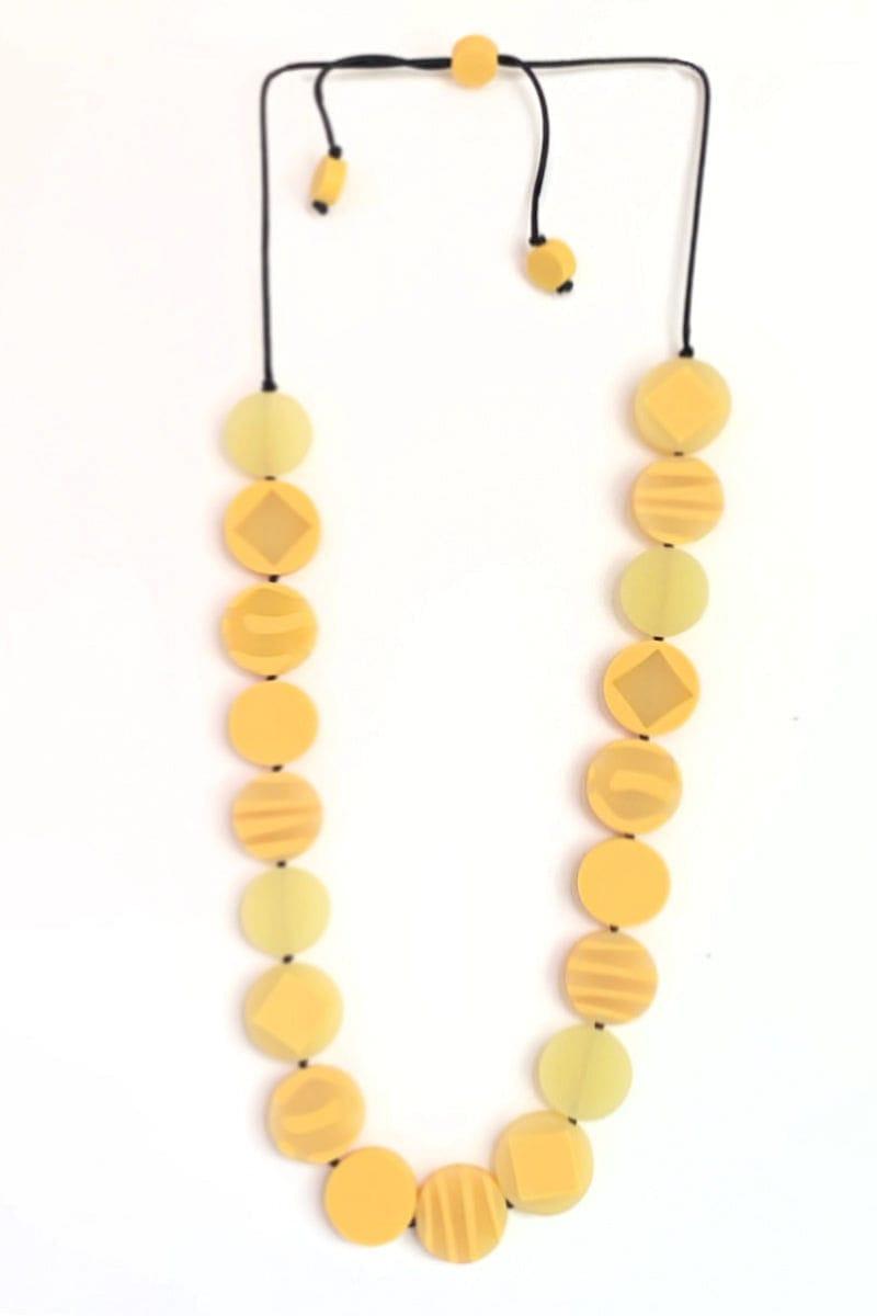 Assorted yellow resin beads strung on a black adjustable wax cord ended with two yellow beads. The flat beads are a blend of solids and graphic designs. 