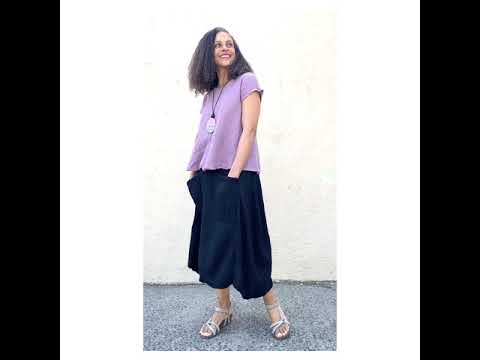 Smiling women wearing a Lavender color textured women's cotton tee with a full cut black cotton skirt with two front pockets. 