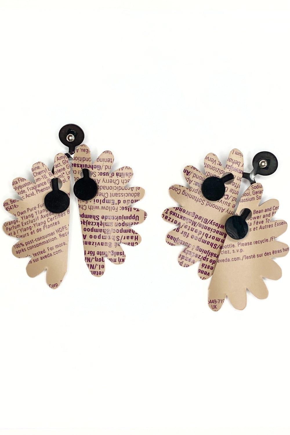 Recycled Earrings made of the plastic from shampoo bottles. Black print agaist light brown.