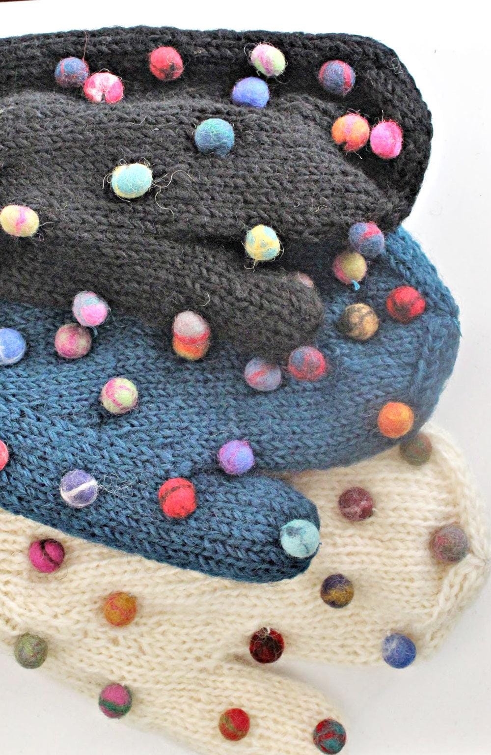 Multi colored felted balls decorated wool mitts. Black, blue and creme mitts.